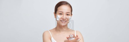 Foto de Feliz riéndose joven mujer asiática lavando la cara con espuma jabón producto cosmético. Banner web - Imagen libre de derechos