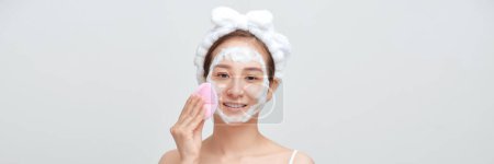 Photo for Panorama of asian female applying foamy cosmetic product on face during skincare routine - Royalty Free Image