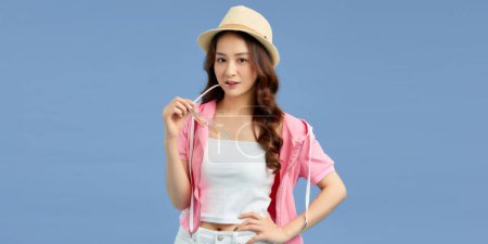 Téléchargez les photos : Jeune élégante belle femme asiatique vêtue de vêtements d'été souriant isolé sur fond bleu. - en image libre de droit
