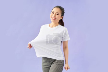 Photo for Slender woman wearing big t shirt, isolated on violet - Royalty Free Image