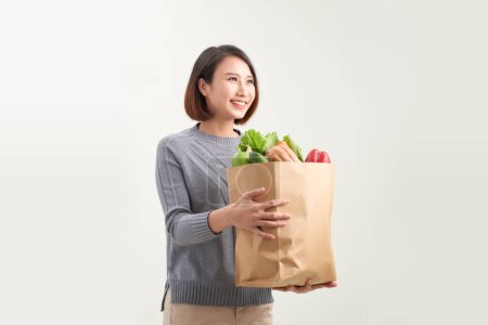 Téléchargez les photos : Sourire femme asiatique heureux tenant un sac de légumes, une alimentation saine et concept de bien-être. - en image libre de droit
