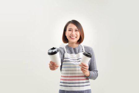 Téléchargez les photos : Portrait de gentille fille sympathique agréable donnant deux grandes tasses isolées sur fond blanc - en image libre de droit