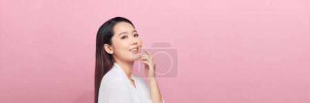Téléchargez les photos : Belle jeune femme asiatique avec une peau propre et fraîche sur fond rose, panorama - en image libre de droit