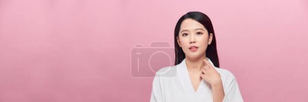 Téléchargez les photos : Une peau parfaite. Joyeux asiatique femme touchant visage sur fond rose. Panorama, - en image libre de droit