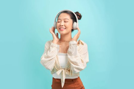 Foto de Feliz, música y auriculares con mujer asiática en estudio para streaming, canto y relax. - Imagen libre de derechos