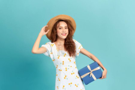 Téléchargez les photos : Une jeune fille heureuse avec cadeau isolé sur fond de couleur bleu pastel - en image libre de droit