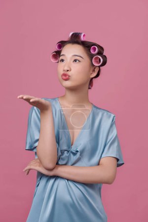 Photo for Beautiful woman with hair-curlers doing funny faces - Royalty Free Image