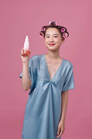Téléchargez les photos : Asiatique jeune femme avec un vaporisateur. Isolé sur fond rose. - en image libre de droit