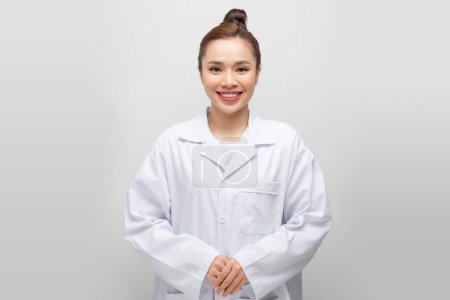 Téléchargez les photos : Souriant jeune asiatique médecin sur fond blanc - en image libre de droit