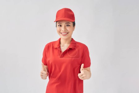 Photo for Image of young Asian delivery woman on white background, showing thumbs up - Royalty Free Image