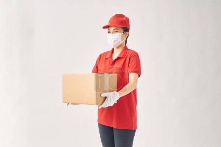 Foto de Mujer como entrega de paquetes mujer aislada sobre fondo blanco vistiendo traje rojo. - Imagen libre de derechos