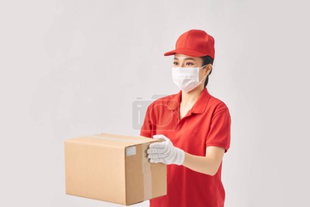 Photo for Female delivery courier in a red uniform smiling while working - Royalty Free Image
