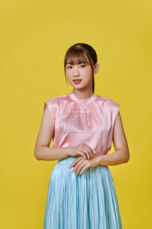 Téléchargez les photos : Jeune femme asiatique souriant sur fond jaune isolé - en image libre de droit