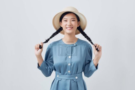 Téléchargez les photos : Mignon jeune asiatique femme avec deux cheveux tresses posant pour caméra - en image libre de droit
