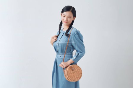 Foto de Hermosa mujer asiática de moda con elegante vestido de mezclilla, con un bolso de hombro redondo - Imagen libre de derechos