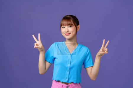 Téléchargez les photos : Asiatique fille montrant V signe et sourire - en image libre de droit