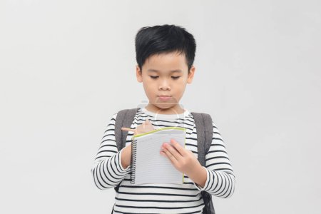 Téléchargez les photos : Bannière de garçon asiatique souriant heureux de 10 ans avec sac à dos et bloc-notes prêts à aller à l'école - en image libre de droit