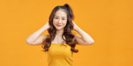 Téléchargez les photos : Jolie asiatique jeune mignon femelle modèle de mode avec pigtails coiffure debout posant regarder caméra - en image libre de droit