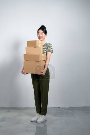 Photo for Happy cute asian woman smiling and holding packages online marketing and delivery - Royalty Free Image
