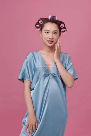 Téléchargez les photos : Belle asiatique femme avec un curler dans son cheveux - en image libre de droit