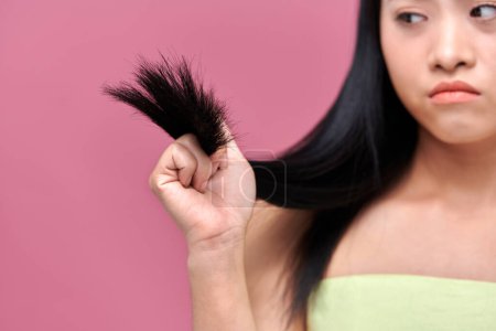 Foto de Asain Mujer con problemas de cabello - concepto de cabello quebradizo, dañado, seco, sucio y con pérdida - Imagen libre de derechos