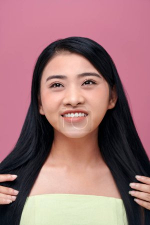 Foto de Atractiva mujer asiática cuidando de su cabello - Imagen libre de derechos