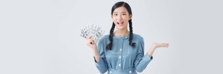 Téléchargez les photos : Funky millennial asian lady point money wear denim dress isolated on white background - en image libre de droit