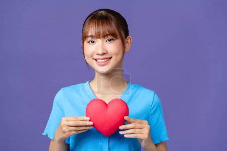 Téléchargez les photos : Femme asiatique avec coeur rouge sur fond violet - en image libre de droit