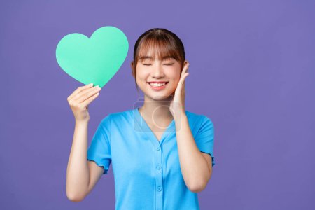 Photo for Young good mood beautiful stunning cute girl hold paper heart  isolated on purple - Royalty Free Image