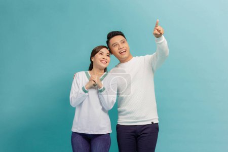 Foto de Joven asiático pareja señaló lado en azul banner fondo - Imagen libre de derechos