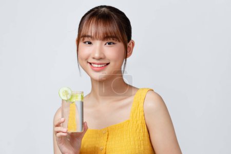 Photo for Calm youthful lady refreshing herself with lemon water - Royalty Free Image
