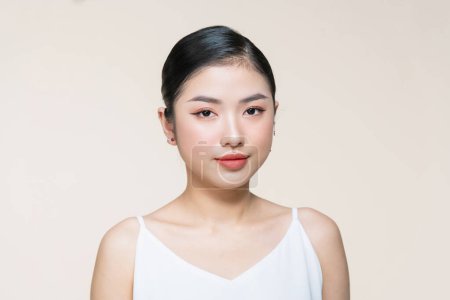 Foto de Retrato de belleza de mujer sonriente asiática con cara limpia y fresca aislada sobre fondo beige - Imagen libre de derechos