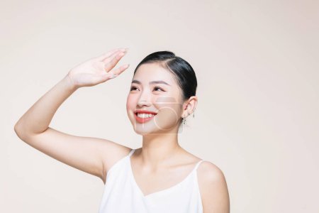 Téléchargez les photos : Belle femme asiatique avec une peau de visage parfaite saine couvrant le visage avec la paume du soleil. - en image libre de droit