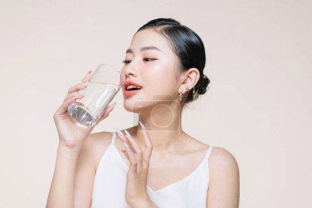 Foto de Joven mujer adulta sostiene un vaso de agua en su mano cerca de la cara - Imagen libre de derechos