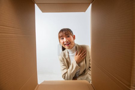 Téléchargez les photos : Femme heureuse avec boîte ouverte, vue de l'intérieur - en image libre de droit