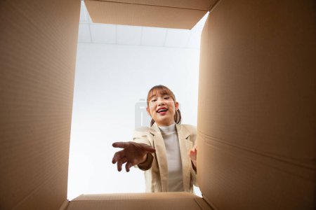 Foto de Mujer joven sonriente abriendo una caja de cartón, reubicación y desembalaje concepto - Imagen libre de derechos