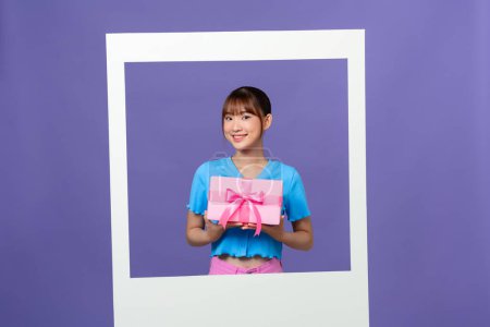 Photo for Photo of lovely asian millennial lady  hold gift box isolated on color background - Royalty Free Image