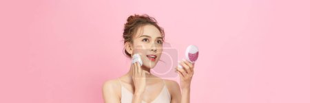 Foto de Primer plano de hermosa hembra con amortiguador soplo y espejo aplicando maquillaje polvo base - Imagen libre de derechos