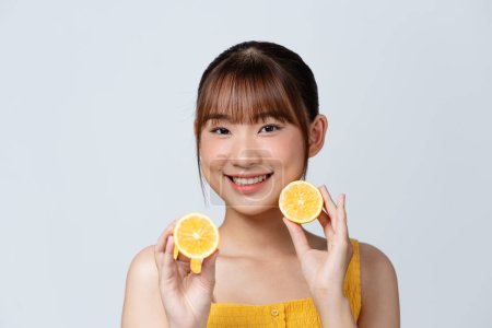 Photo for Cheerful feminine girl with natural clear skin and two lemon slices, isolated on a white background - Royalty Free Image