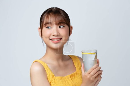 Foto de Hermosa asiática con limón y vaso de agua - Imagen libre de derechos