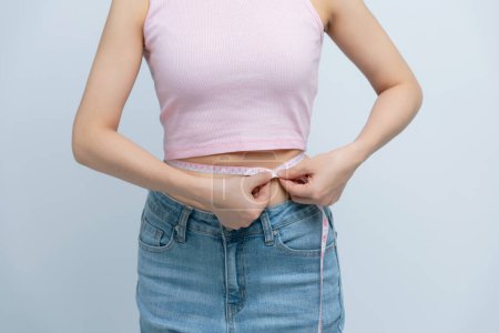 Foto de Tiro recortado de la mujer que mide su cintura aislada en blanco - Imagen libre de derechos