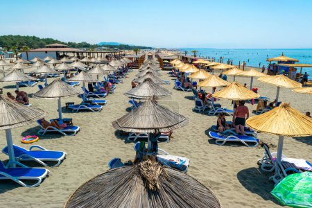 Photo for Ulcinj, Montenegro - 09 July 2021: Vacationers on sand Long Beach (Velika plaza) with umbrellas and sun loungers. Sunny blue seaside landscape. Adriatic Sea. - Royalty Free Image