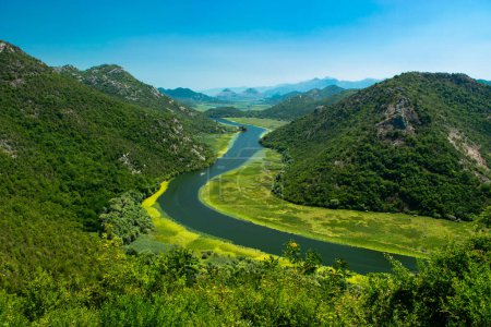 Aussichtspunkt Pavlova Strana. Schöne Sommerlandschaft mit grünen Bergen, blauem Himmel und einer Kurve des Flusses Crnojevica, der in den Skadar-See mündet. Montenegro. Reisekonzept.