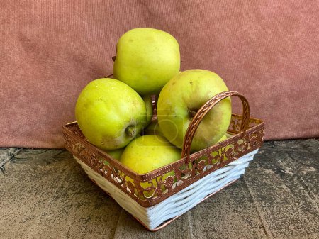 Téléchargez les photos : Bundle de pommes vertes dans le panier au canapé - en image libre de droit