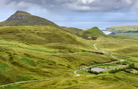 Photo for In mid summer,looking down to the sea and Staffin Bay,beautiful green moorland landscape,jagged mountains with narrow single track roads. - Royalty Free Image