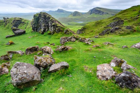 Photo for Beautiful,dramatic Scottish mountainous scenery,pointed,jagged mountain peaks and sheer cliff faces, along the Quiraing hills walk,green grass and shrub covered in the mid summer,north eastern Skye. - Royalty Free Image