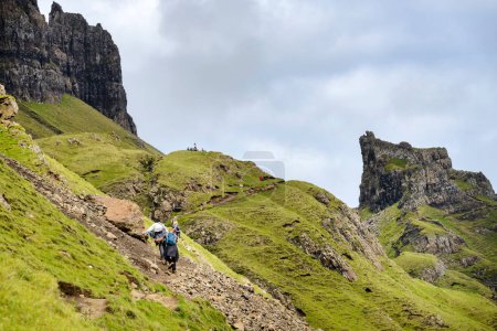 Téléchargez les photos : Quiraing, île de Skye, Écosse, Royaume-Uni-25 juillet 2022 : Les randonneurs marchent le long des sentiers de montagne de la chaîne de montagnes de Quraing,, un jour d'été, profitant de la vue spectaculaire sur le paysage. - en image libre de droit