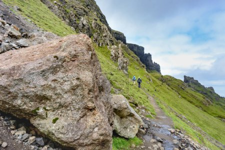 Photo for Quiraing,Isle of Skye,Scotland,UK-July 25 2022: Hikers walk along the mountain paths of the Quraing mountain range,,on a summer day,taking in the dramatic,landscape views. - Royalty Free Image