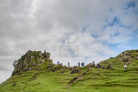 Téléchargez les photos : Trotternish, île de Skye, Écosse, Royaume-Uni 26 juillet 2022 : Pendant les vacances d'été, de nombreux visiteurs marchent sur la crête jusqu'au rocher en forme de château et profitent d'une vue sur les paysages verdoyants et fantastiques. - en image libre de droit