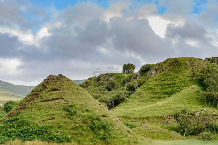 Téléchargez les photos : Château comme basalte rocheux proéminence, avec de belles vues sur les environs, collines en forme de cône et monticules, un paysage mignon, surréaliste, fantasme comme, herbe couverte. Un site touristique populaire près d'Uig sur Skye. - en image libre de droit